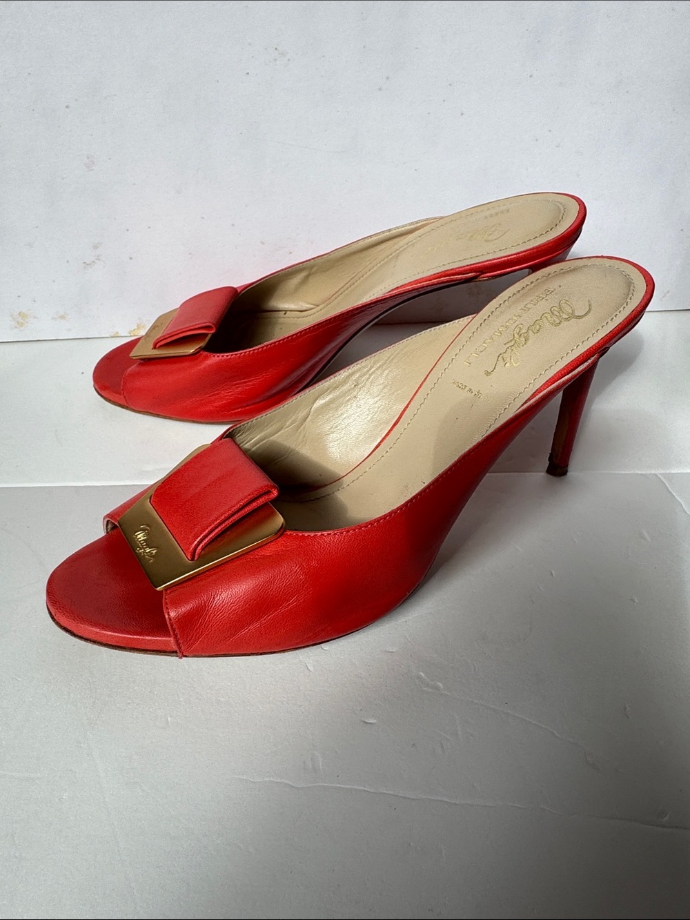 Bruno Magli leather mules with a gold-tone hardware plaque